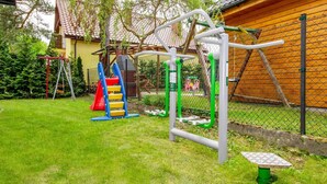 An outdoor playground with various equipment including a slide, climbing steps, and hanging bars. - 1 bedroom beautiful apartment in Jaroslawiec (Jaroslawiec)