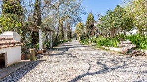 A gravel path leading to a reception area with a sign for 'Recipcion Berrocal Turismo'.
