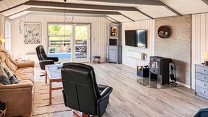 Ein gemütliches Wohnzimmer mit Kamin, Fernseher und Essbereich mit Tisch und Stühlen.