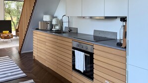 A modern kitchen with wooden cabinetry, a built-in oven, and a coffee maker. - Pet friendly home in Löttorp with WiFi (Löttorp)