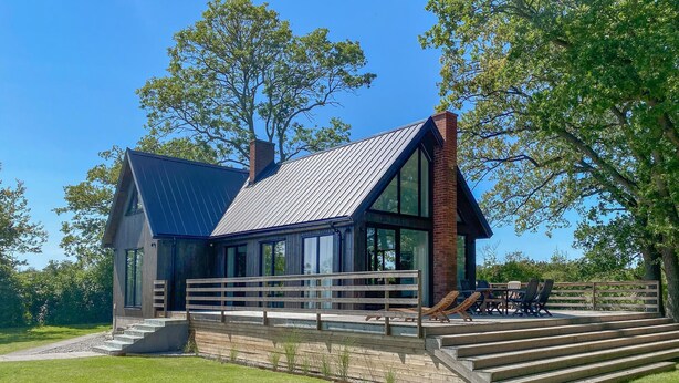 A modern house with a large deck, a brick chimney, and a metal roof. - Pet friendly home in Löttorp with WiFi (Löttorp)