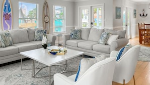 A living room with a grey sofa set, a white coffee table, and a ceiling fan.