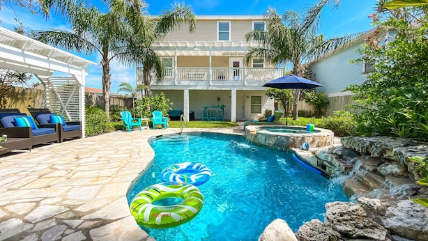 A backyard with a swimming pool, lounge chairs, and a pergola.