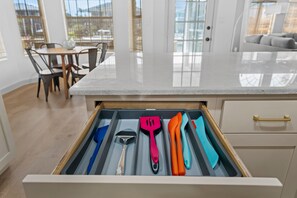 Una cocina con un cajón que contiene varios utensilios.