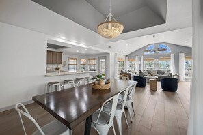 A spacious kitchen with a dining area, large windows, and a ceiling fan. - NEWLY REMODELED - Rockport Waterfront Oasis (Rockport)