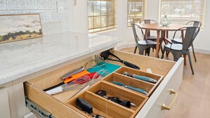 A kitchen with a wooden drawer organizer containing various utensils. - NEWLY REMODELED - Rockport Waterfront Oasis (Rockport)