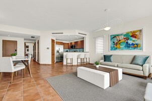 Una sala de estar moderna con sofá, mesa de centro y comedor.