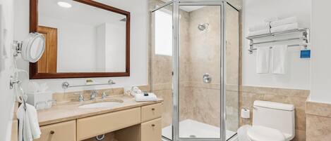 A modern bathroom with a glass-enclosed shower, a double sink vanity, and a toilet.