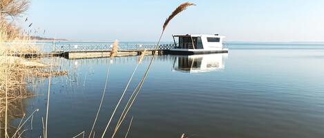A calm lake with a dock and a stationary boat.