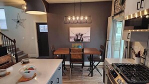 Una cocina moderna con una isla central, una mesa de comedor y una estufa.