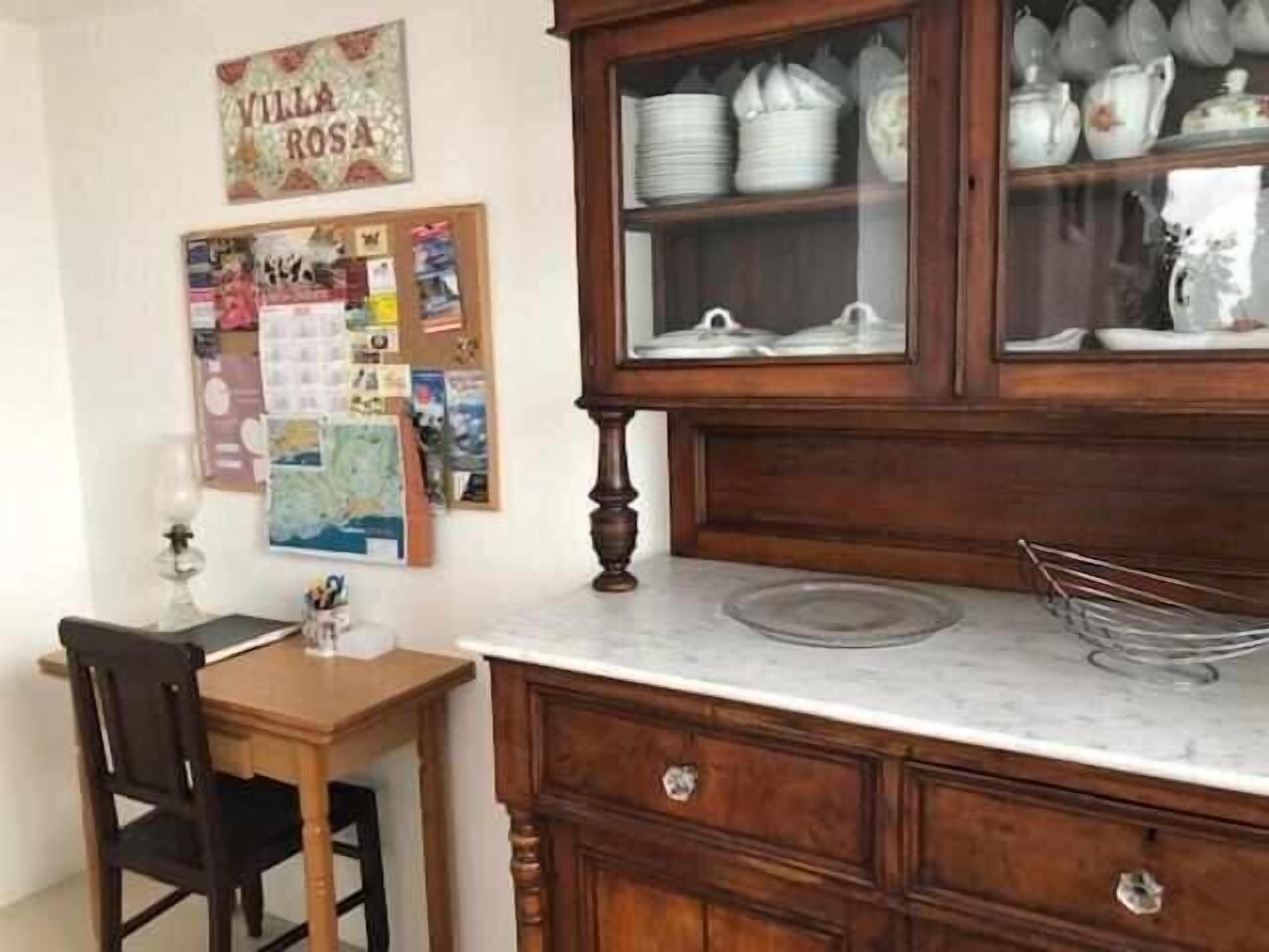 Une cuisine dotée de meubles en bois, d’un plan de travail en marbre et d’un coin repas avec une table et des chaises.
