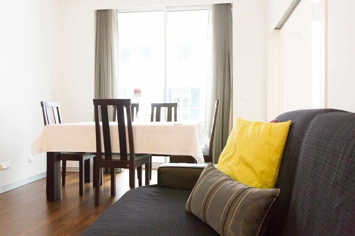 A living room with a sofa, a dining table, and chairs.