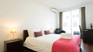 Une chambre d’hôtel avec un grand lit, deux lampes de chevet, un bureau et une chaise.