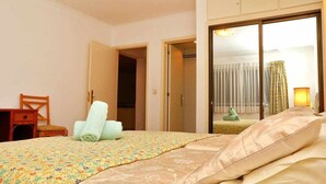 Ein Hotelzimmer mit einem Bett, einem Sessel, einem Schreibtisch und einem Kleiderschrank.