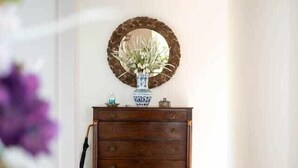 A hallway with a wooden dresser, a mirror, and a vase with flowers. - Vila da Falésia-With Pool and views (Caniço)