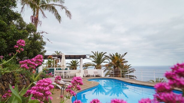 A swimming pool with lounge chairs and a view of the ocean. - Vila da Falésia-With Pool and views (Caniço)