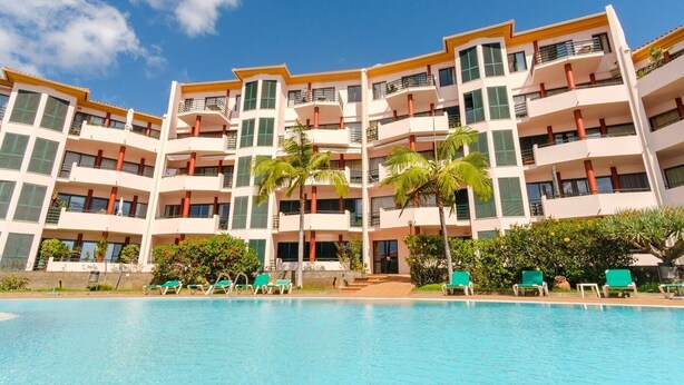 A multi-story hotel with a swimming pool, palm trees, and green lounge chairs. - Varandas Funchal-Near center (Funchal)