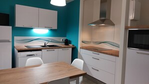 A modern kitchen with white cabinets, a wooden countertop, a built-in oven, and a stainless steel range hood.