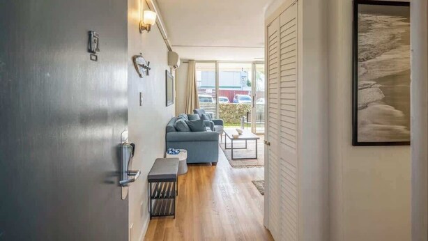 A modern interior with a sofa, a small table, and a door with a number.