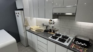 Una cocina moderna con armarios blancos, una campana extractora de acero inoxidable y una encimera negra.