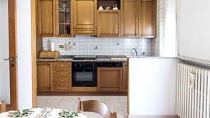 Una cocina con armarios de madera, encimera, estufa y lavavajillas.