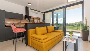Ein zeitgemäßer Wohnbereich mit Sofa, Essplatz und Küche.