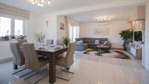 Una sala de estar moderna con comedor, un sofá y una mesa de centro.