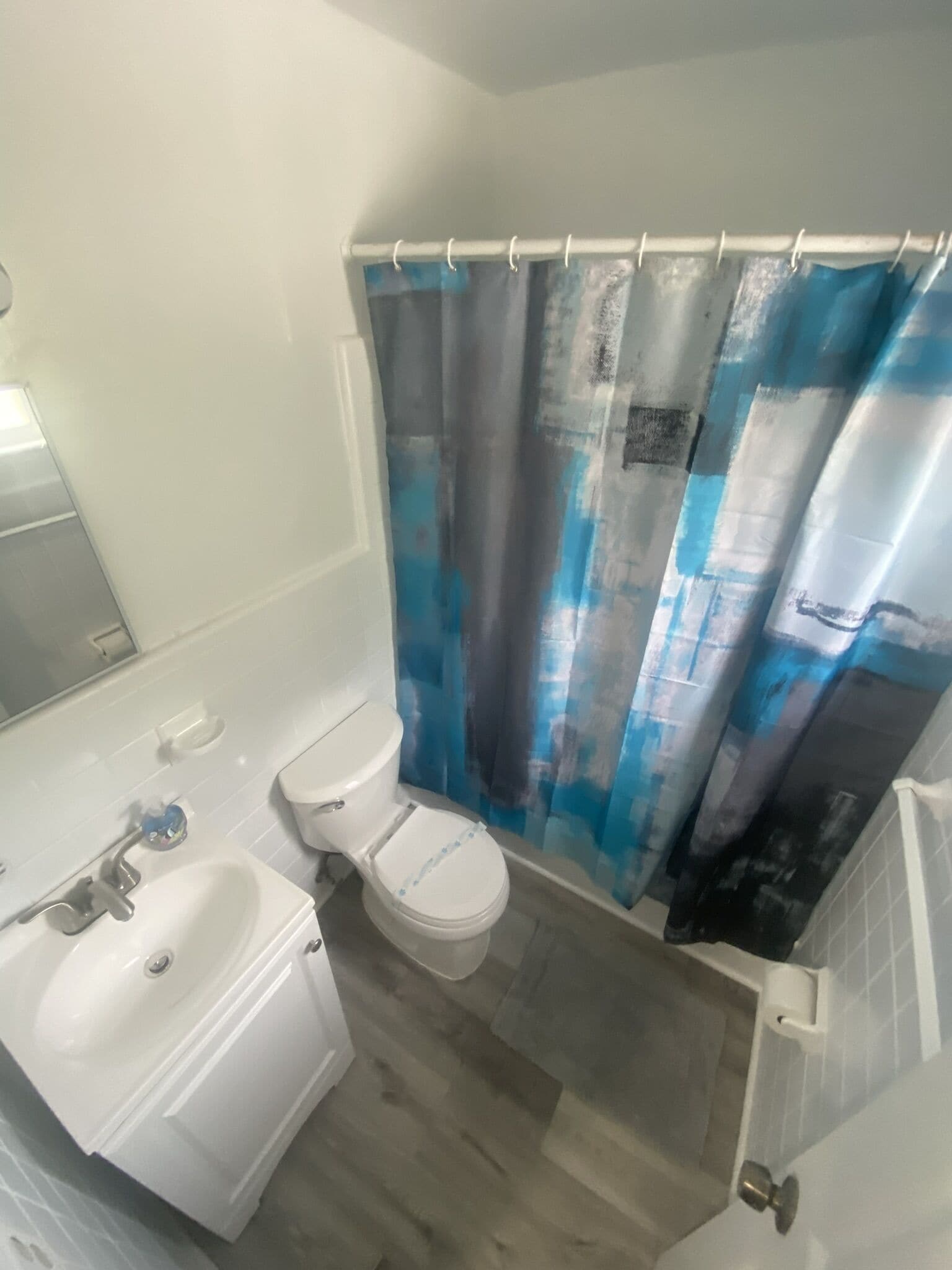 A bathroom with a white sink, toilet, and bathtub.