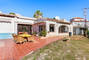 Une maison avec un patio, une piscine et un jardin.