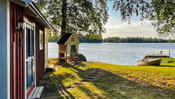 A lakeside cabin with a dock, a small shed, and a wooden bench. - Stunning home in Eringsboda with sauna (Eringsboda)