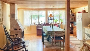 A cozy kitchen with wooden beams, a dining table with chairs, a stove, and a refrigerator. - Stunning home in Eringsboda with sauna (Eringsboda)