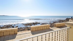 A coastal view with a clear sky, rocky shoreline, and a distant landmass. - Cozy home in Sampieri with WiFi (Sampieri)