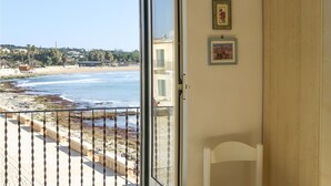 A room with a view of the beach, a door, and two framed pictures on the wall. - Cozy home in Sampieri with WiFi (Sampieri)