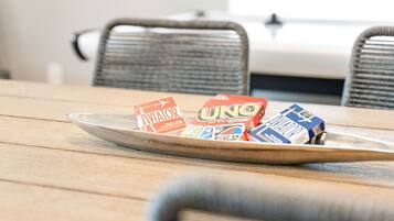 Une table à manger sur laquelle se trouve un plateau en métal contenant des jeux de cartes UNO et Aviator.
