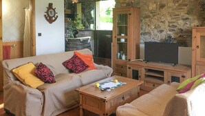 Uma sala de estar acolhedora com sofá, mesa de centro e aparador para TV.