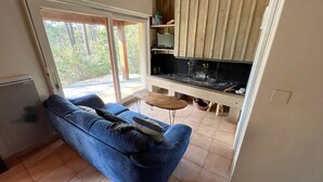 A living room with a blue sofa, a small wooden table, and a built-in fireplace.
