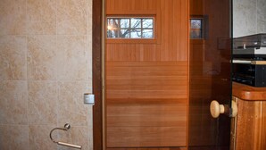 A wooden door with a small window, a towel rack, and a wooden panel wall.