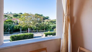 A balcony with a view of a residential area, a stop sign, and a red car parked on the street. - Lovely apartment in Ortona with WiFi (Ortona)