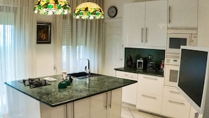 Una cocina con una isla central, un fregadero, una estufa y un refrigerador.