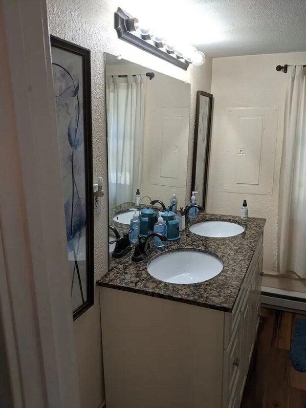 A bathroom with two sinks, a mirror, and a vanity.