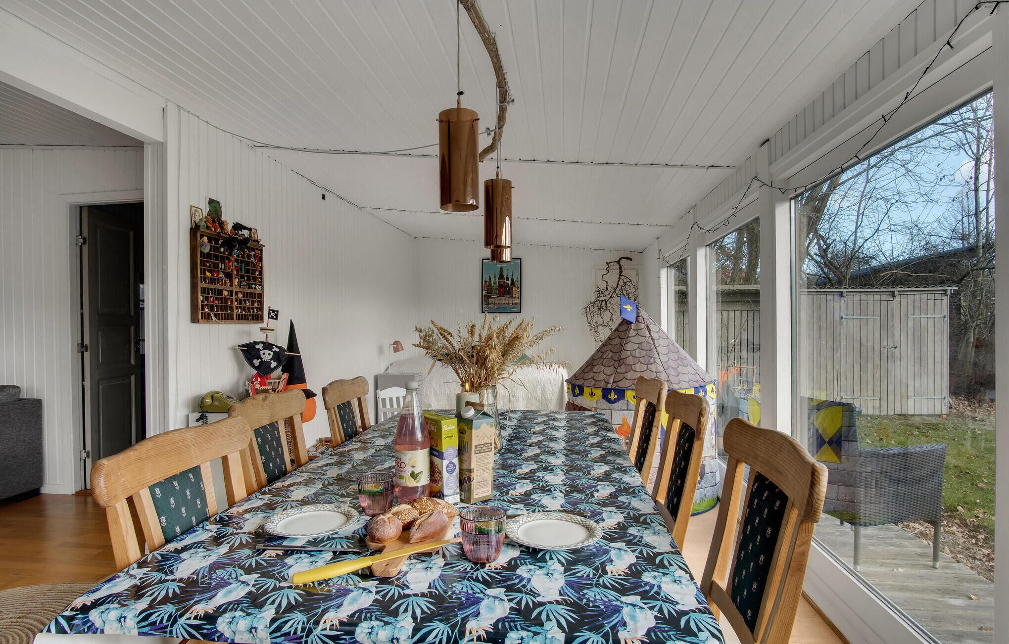A dining area with a long table, chairs, and a tent-like structure.
