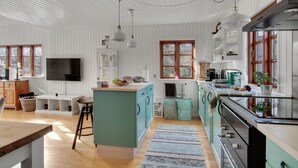A spacious kitchen with white wooden walls, a central island, and a large window. - Beautiful home in Grevinge with kitchen (Grevinge)