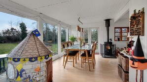A dining area with a large table and chairs, a fireplace, and a view of the outdoors. - Beautiful home in Grevinge with kitchen (Grevinge)