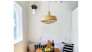 A cozy corner with a wooden table, a woven pendant light, and a bench with cushions. - Beachy Boho located in the Heart of Encinitas (Encinitas)