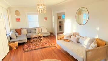A cozy living room with a sofa set, a coffee table, and a patterned rug.