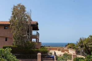 A two-story building with a balcony overlooking the sea.