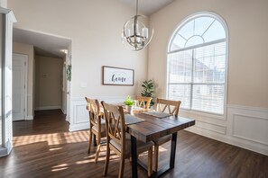 Enjoy meals in this inviting dining area with a large window, wooden table, and comfortable seating.