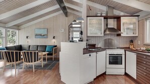 Una cocina moderna con armarios blancos, horno empotrado y campana de acero inoxidable.