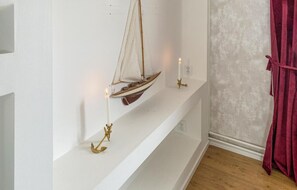 A shelf with a model sailboat and candles. - Amazing apartment in Sommen with WiFi (Sommen)