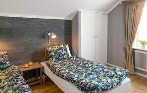 A bedroom with a bed, bedside table, lamp, wardrobe, and a window with curtains. - Amazing apartment in Sommen with WiFi (Sommen)